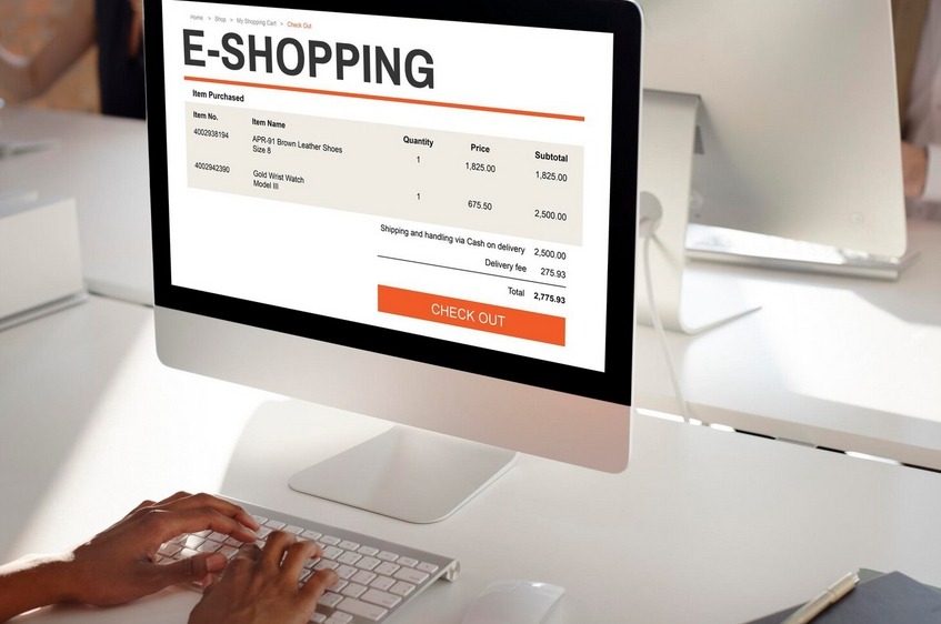 A person using a computer to check out items on an online shopping website, displaying a cart summary.